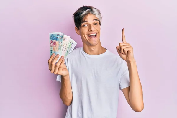 Joven Hispano Sosteniendo Billetes Dólar Singapurenses Sonriendo Con Una Idea —  Fotos de Stock