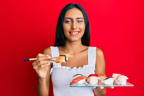 Jovem Morena Comendo Sushi Omelete Usando Pauzinhos Piscando Olhando Para — Fotografia de Stock