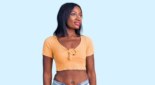 若いアフリカ系アメリカ人の女性の顔に笑顔で横に見えるカジュアルな服を着て 自然な表情 自信を持って — ストック写真