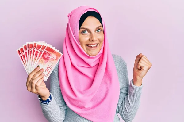 Νεαρή Καυκάσια Γυναίκα Φορώντας Ισλαμική Μαντίλα Κρατώντας Χαρτονομίσματα Των Σέκελ — Φωτογραφία Αρχείου
