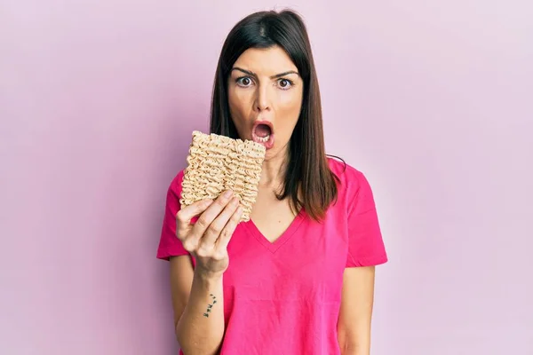 Young Hispanic Woman Holding Uncooked Noodles Scared Amazed Open Mouth — Φωτογραφία Αρχείου