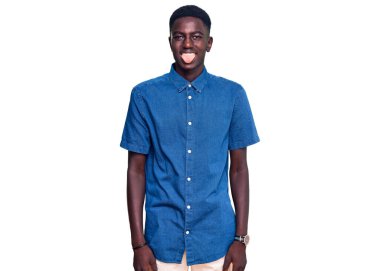 Genç, Afro-Amerikan bir adam günlük kıyafetler giyiyor. Dilini komik bir ifadeyle dışarı çıkarıyor. duygu kavramı. 