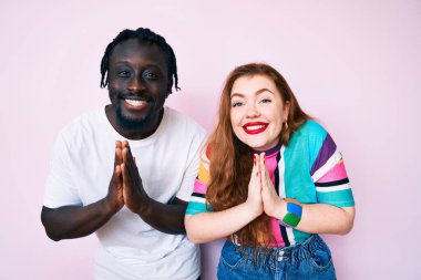 Irklar arası çift, günlük kıyafetler giyip ellerinin birbiri ile dua ederek af diler.. 