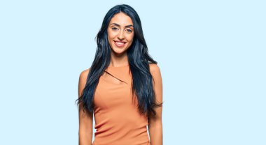 Güzel İspanyol kadın yaz elbisesi giyiyor. Pozitif ve mutlu görünüyor. Duruyor ve gülümsüyor. 