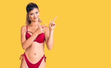 Bikini giyen genç ve güzel bir kadın endişeli ve gergin bir ifadeyi işaret ediyor. 