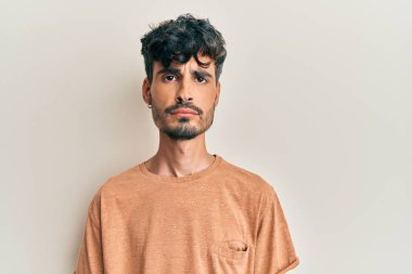 Günlük giysiler giyen genç İspanyol bir adam depresyonda ve sıkıntıdan endişe ediyor, kızgın ve korkmuş bir şekilde ağlıyor. hüzünlü ifade. 