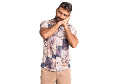 Yazlık giysiler giyen genç İspanyol adam yorgun uyuyor. Hayal kuruyor, elleriyle poz veriyor ve gözleri kapalı gülümsüyor.. 