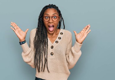 Sıradan kıyafetler giyen Afrikalı Amerikalı bir kadın çılgın ve başarıyı kollarını kaldırıp heyecanla haykırarak kutluyor. Kazanan konsept 