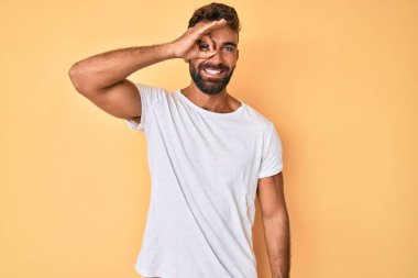 Gündelik giysiler giyen genç İspanyol adam gülümsüyor. Mutluluktan gülümsüyor. 