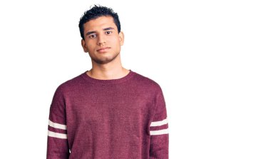 Günlük kıyafetler giyen İspanyol yakışıklı genç adam yüzünde ciddi bir ifadeyle rahatladı. Basit ve doğal bir şekilde kameraya bakıyorsun.. 