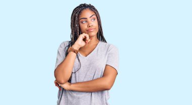 Saçları gündelik giyinmiş, ciddi yüzlü, eli çenesinde soru soran, kafa karıştırıcı fikirleri olan Afro-Amerikalı genç bir kadın. 