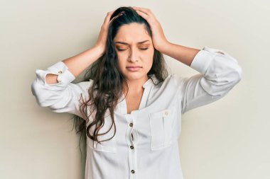 Güzel bir ortadoğulu kadın gündelik kıyafetler giyip baş ağrısı çekiyor. Acı ve migrenden dolayı çaresiz ve stresli. Eller başının üstünde.. 