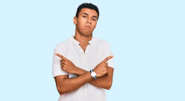 Gündelik giysiler giyen genç bir Arap her iki tarafı da parmaklarıyla işaret ediyor, farklı yönlerde farklı görüşler. 