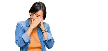 Kısa saçlı, sıradan bir kot ceket giyen, yüzünü ellerle örten ve ağlayan genç, güzel İspanyol bir kadın. depresyon kavramı. 