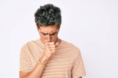 Sıradan kıyafetler giyen genç yakışıklı adam kendini iyi hissetmiyor ve soğuk algınlığı veya bronşitin belirtisi olarak öksürüyor. sağlık hizmeti kavramı. 