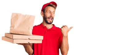 Sakallı yakışıklı sarışın adam yiyecekleri alıp başparmağını kaldırıyor ve ağzı açık gülümsüyor. 