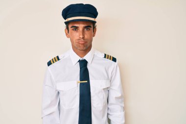 Uçak pilotu üniforması giyen genç bir İspanyol bunalımlı ve üzüntülü, sinirli ve korkmuş bir şekilde ağlıyor. hüzünlü ifade. 