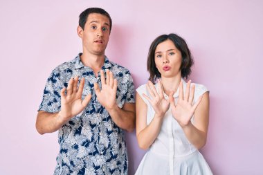 Güzel bir çift gündelik giysiler giyer, avuç içlerine dokunur. Korkmuş ve iğrenç bir ifadeyle reddeder. Dur ve yasakla. 