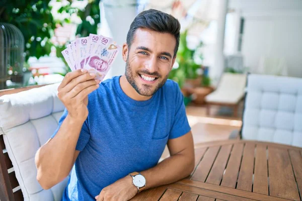 Joven Hispano Sonriendo Feliz Sosteniendo Billetes Mexicanos Terraza —  Fotos de Stock