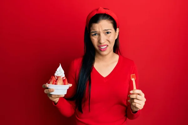 アイスクリームを持っている若いラテン語の女性は無知で混乱した表情 疑わしい概念 — ストック写真