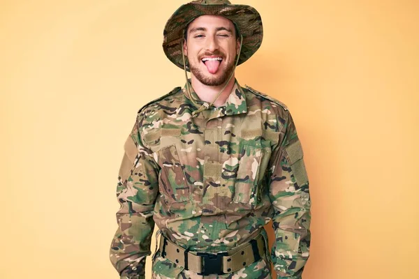 Jovem Caucasiano Vestindo Uniforme Exército Camuflagem Furando Língua Feliz Com — Fotografia de Stock