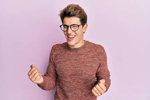 스웨터를 안경을 잘생긴 코카서스 남성이 성공을 노려보며 웃으며 감았다 — 스톡 사진