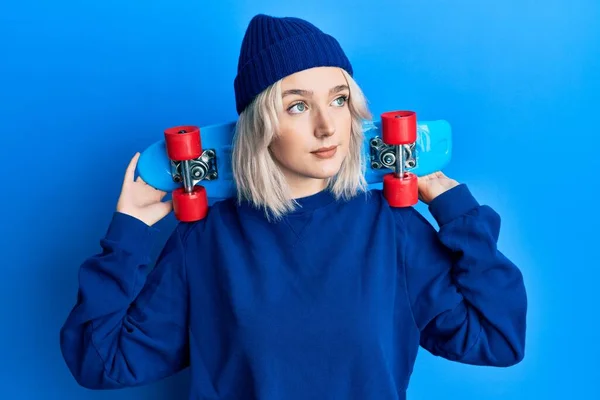 Menina Loira Jovem Segurando Skate Sorrindo Olhando Para Lado Olhando — Fotografia de Stock