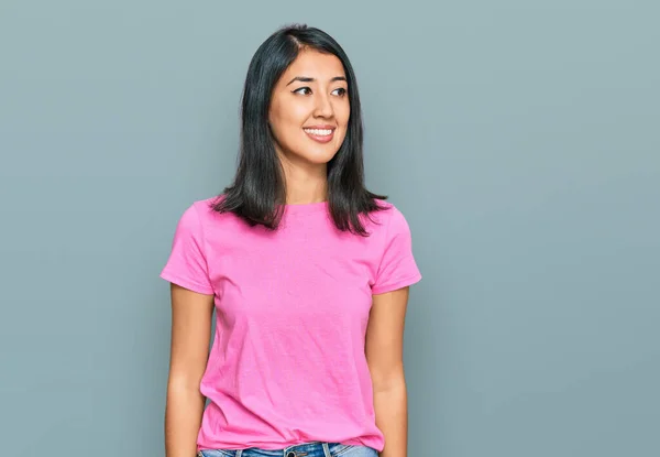 아름다운 아시아인젊은 여성이 분홍색 티셔츠를 얼굴에 미소를 머금고 바라보고 있습니다 — 스톡 사진
