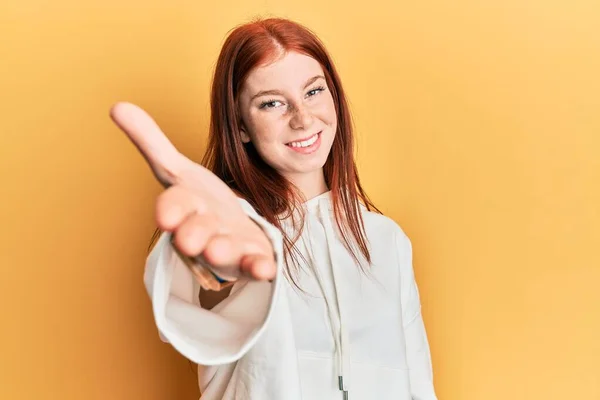 年轻的红头发女孩穿着休闲装 笑容满面 友善地握手致意和欢迎 成功的商业 — 图库照片