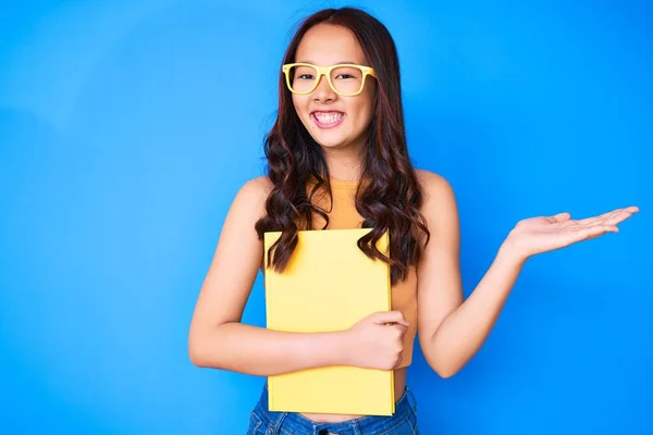 Jovem Menina Chinesa Bonita Usando Óculos Segurando Livro Celebrando Vitória — Fotografia de Stock