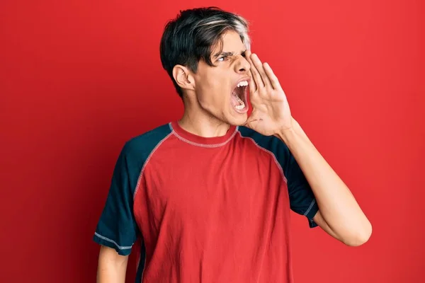 若いヒスパニック系の男はカジュアルな服を叫んで大声で口の上に手で横に叫んで身に着けている コミュニケーションの概念 — ストック写真
