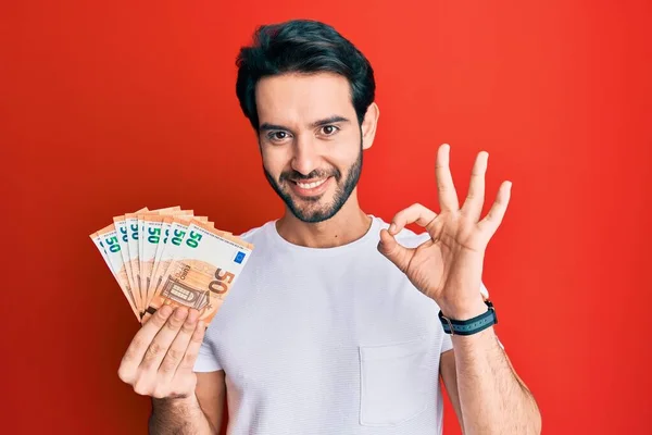Ung Latinamerikansk Man Som Håller Eurosedlar Gör Tecken Med Fingrar — Stockfoto