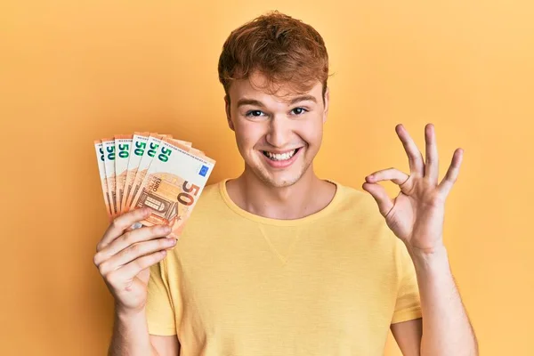Jonge Kaukasische Man Met Een Bos Van Eurobankbiljetten Die Teken — Stockfoto
