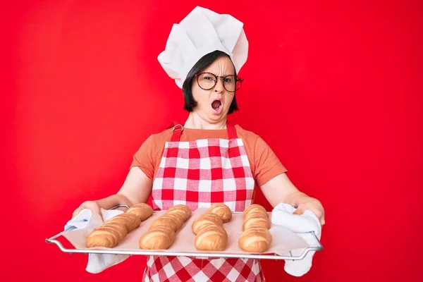 Brünette Frau Mit Syndrom Trägt Bäckeruniform Mit Selbstgebackenem Brot Schockgesicht — Stockfoto