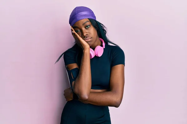 Young African American Woman Wearing Gym Clothes Using Headphones Thinking — Stock Photo, Image