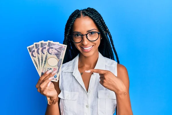 Hermosa Mujer Hispana Sosteniendo Billetes Yen Japoneses Sonriendo Feliz Señalando —  Fotos de Stock