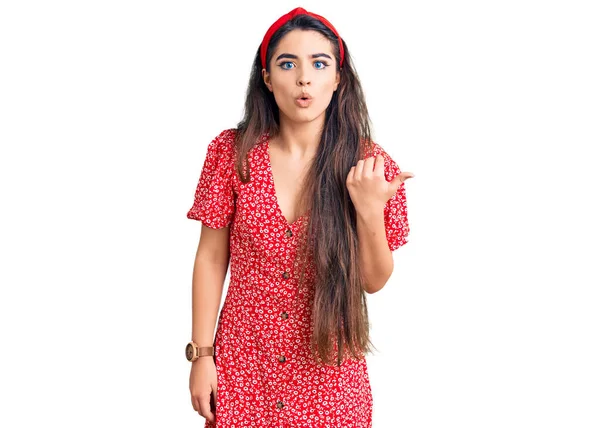 Brunette Teenager Girl Wearing Summer Dress Surprised Pointing Hand Finger — Stock Photo, Image