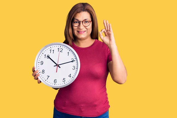 Mujer Latina Mediana Edad Sosteniendo Reloj Grande Haciendo Signo Con —  Fotos de Stock
