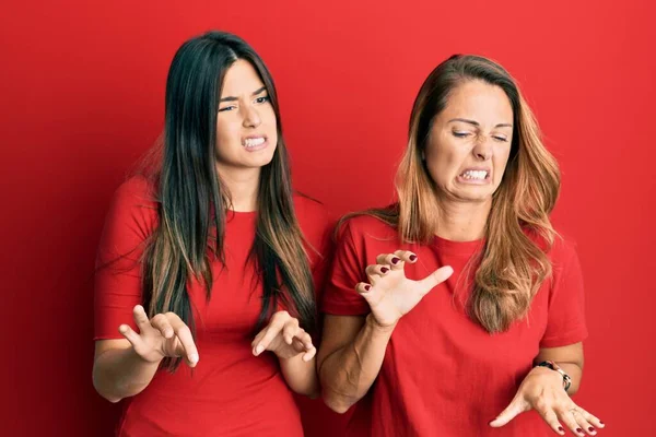 Família Hispânica Mãe Filha Vestindo Roupas Casuais Sobre Fundo Vermelho — Fotografia de Stock