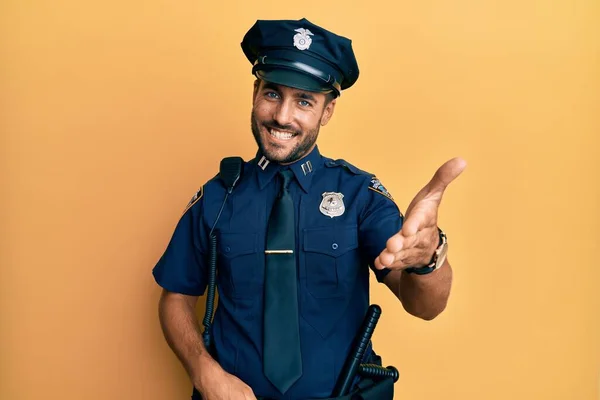 Snygg Hispanic Man Klädd Polis Uniform Ler Glad Erbjuda Handflatan — Stockfoto