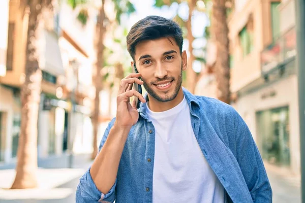Jovem Latino Sorrindo Feliz Falando Smartphone Andando Cidade — Fotografia de Stock