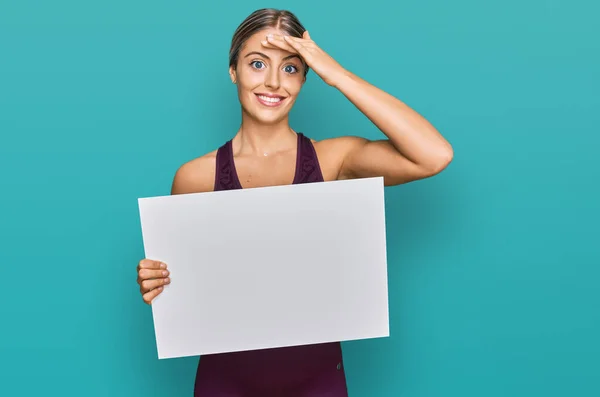 Beautiful Blonde Woman Wearing Sportswear Holding White Banner Stressed Frustrated — Stock Photo, Image