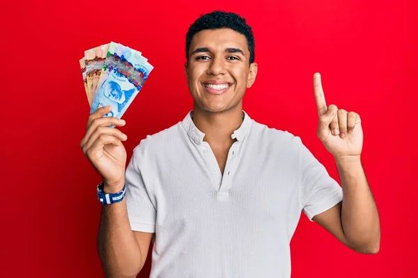 Hombre Árabe Joven Sosteniendo Dólares Canadienses Sonriendo Con Una Idea —  Fotos de Stock
