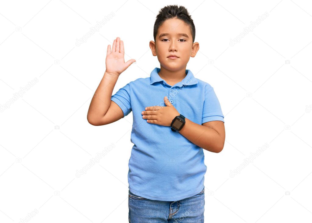 Little boy hispanic kid wearing casual clothes swearing with hand on chest and open palm, making a loyalty promise oath 
