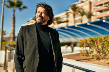 Orta yaşlı işadamı şehirde mutlu mesut dikilirken.