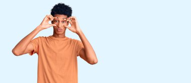 Gündelik giysiler giymiş genç Afro-Amerikan adam parmaklarıyla gözlerini açmaya çalışıyor, uykulu ve yorgun bir şekilde sabah yorgunluğu çekiyor. 