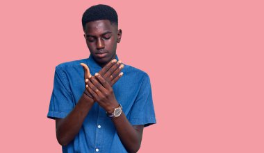 Genç Afro-Amerikan adam günlük kıyafetler giyiyor. Ellerinde ve parmaklarında ağrı var. Eklem iltihabı. 