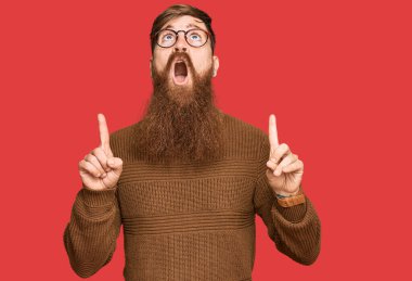 Genç İrlandalı kızıl elbiseli, gözlüklü, şaşkın ve şaşırmış bir halde yukarı bakıp, parmaklarıyla işaret ediyor ve kollarını kaldırıyordu.. 