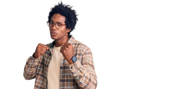 Yakışıklı Afro saçlı, sıradan giyinmiş ve gözlüklü, dövüşmek için yumruk atan saldırgan ve öfkeli saldırı, tehdit ve şiddet dolu bir Amerikalı. 