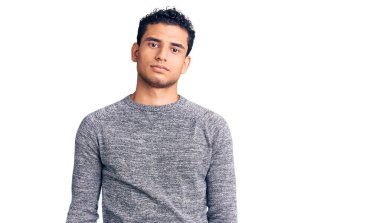 Gündelik kazak giyen İspanyol yakışıklı genç adam yüzünde ciddi bir ifadeyle rahatladı. Basit ve doğal bir şekilde kameraya bakıyorsun.. 